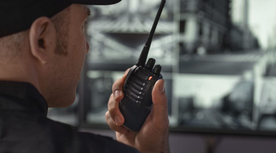 portrait-male-security-guard-with-radio-station-camera-screens